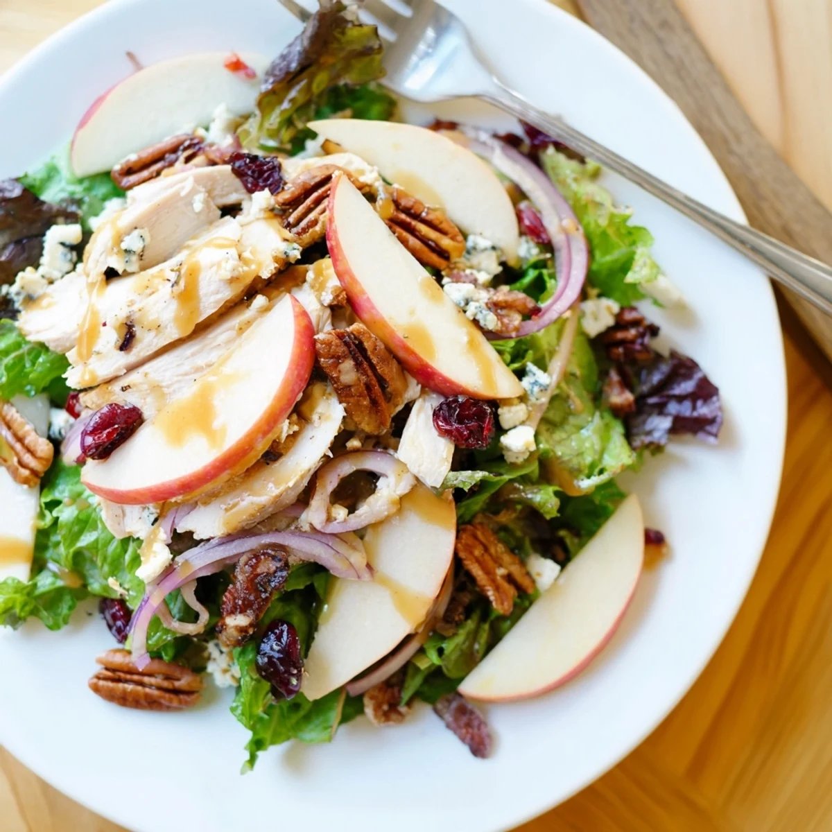 Close-up of a freshly tossed Caramel Apple Chicken Salad showing feta, cranberries, and red onion for a sweet and savory flavor.