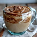 Steamed milk being gently poured to create a rich, foamy layer on a warm Hojicha Cappuccino.