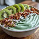 Earthy roasted green tea smoothie bowl served with crunchy granola and fresh fruit for breakfast.