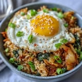 Spicy, tangy kimchi fried rice bowl, perfectly seasoned and topped with fresh green onions.