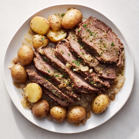 Tender, fall-apart simple slow cooker pot roast, served with golden potatoes and savory broth.