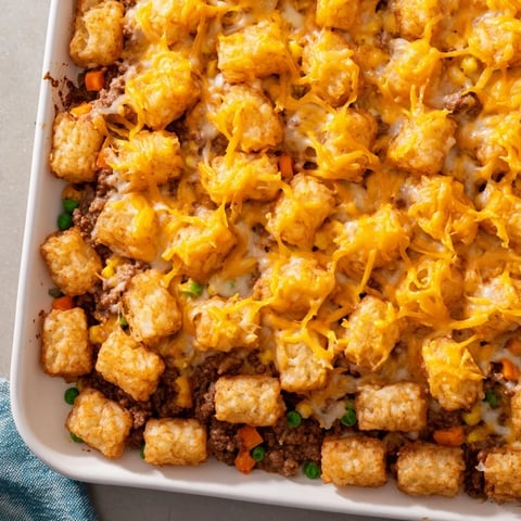 Golden, bubbly Family Favorite Tater Tot Casserole in a baking dish, ready to serve with a crisp salad.