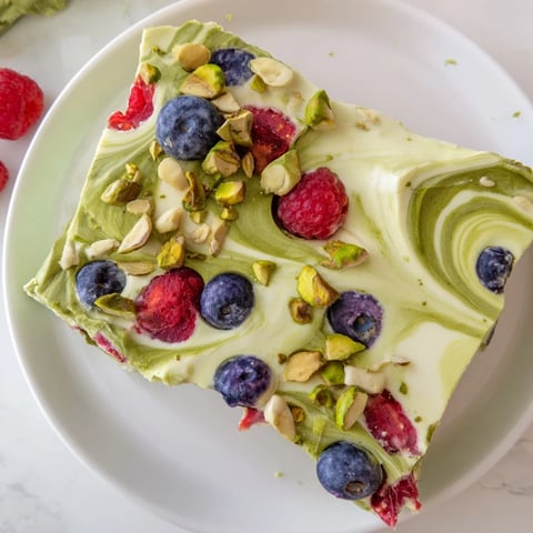 Creamy frozen yogurt bark swirled with vibrant berries and pistachios, a refreshing, healthy treat.