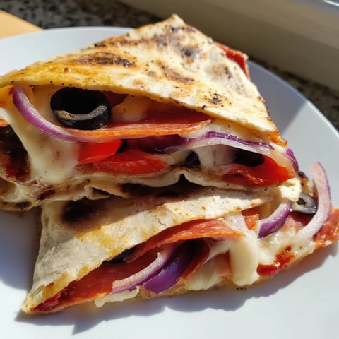 Folded and pan-toasted, this crispy Tortilla Pizza Wrap oozes melted mozzarella with colorful veggie toppings.  