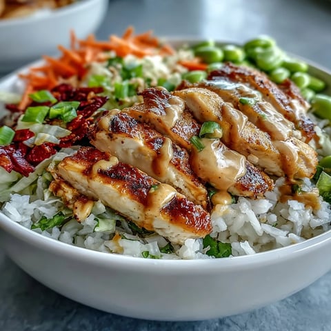 Fluffy coconut rice topped with tender grilled chicken, crisp red cabbage, and vibrant carrots in a bowl.