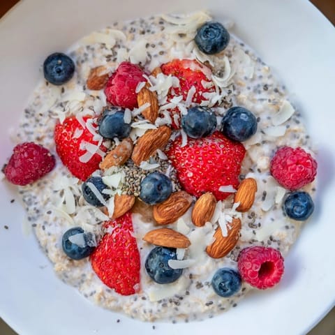 A close-up of overnight oats with berries shows vibrant fruit and chia seeds.