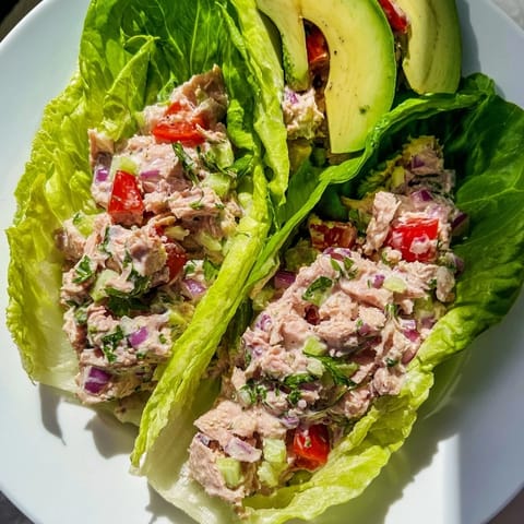 Close-up of quick & healthy tuna salad lettuce wraps, showing the flavorful filling inside crisp lettuce cups.