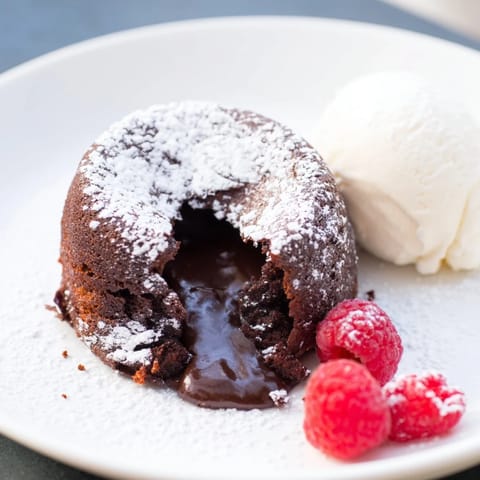 A decadent close-up shows the rich, dark chocolate of individual mini chocolate lava cakes.