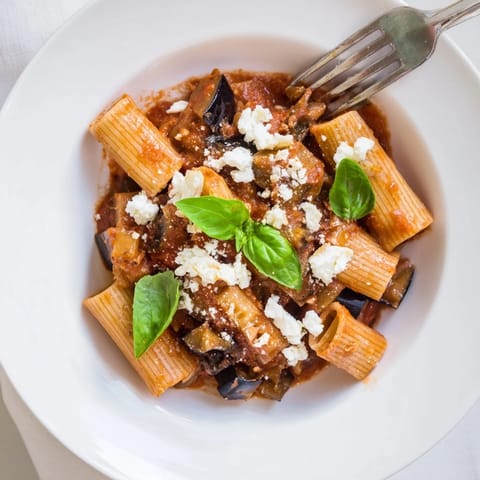 Savory Pasta Alla Norma features tender roasted eggplant, aromatic basil, and crumbly ricotta salata over perfectly cooked pasta.  