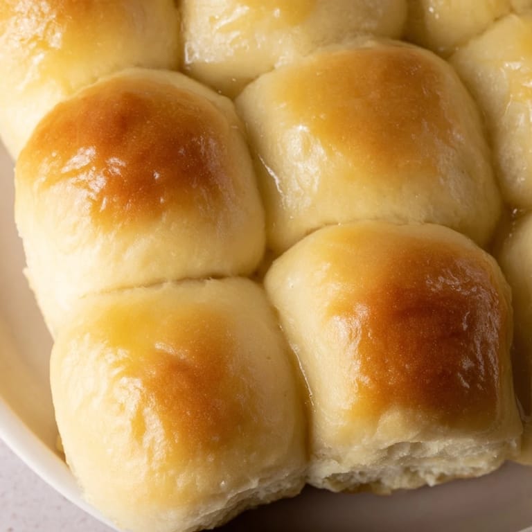 A close-up of fluffy Homemade Golden Dinner Rolls, showing a perfect, tender, and inviting texture.