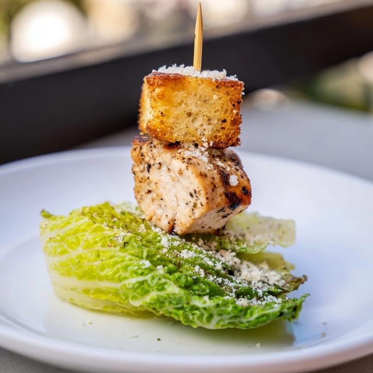 Appetizing close-up of Chicken Caesar Salad Skewers, showcasing grilled chicken and drizzled Caesar dressing.