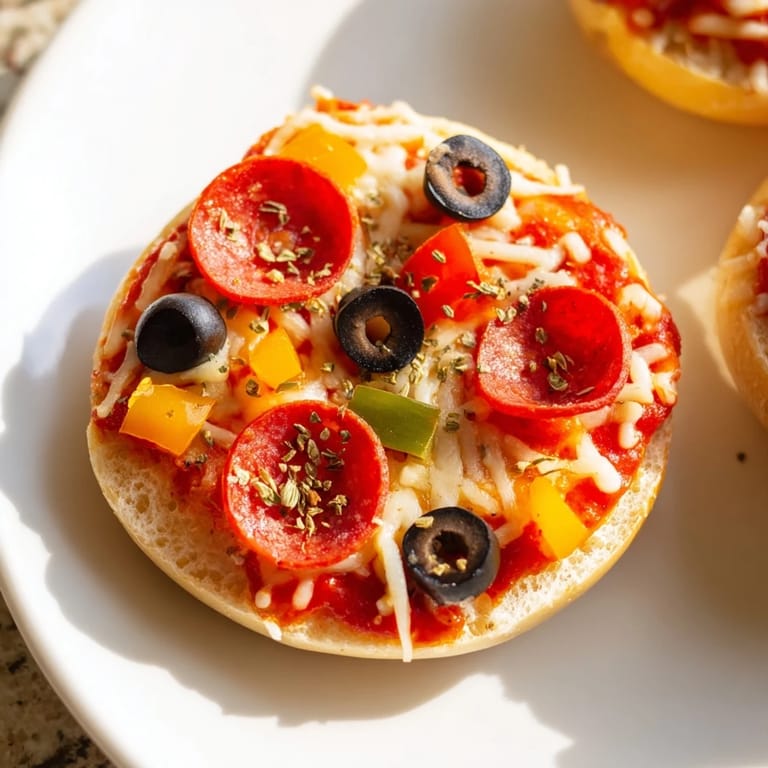 Air-fried mini bagel pizzas with melted cheese and pepperoni, ready for a delicious, quick meal.