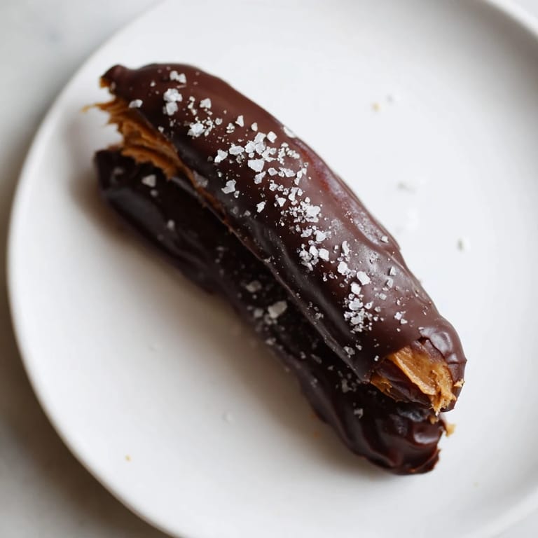 Creamy peanut butter-stuffed Chocolate Peanut Butter Dates, dipped in decadent dark chocolate, ready to be enjoyed.