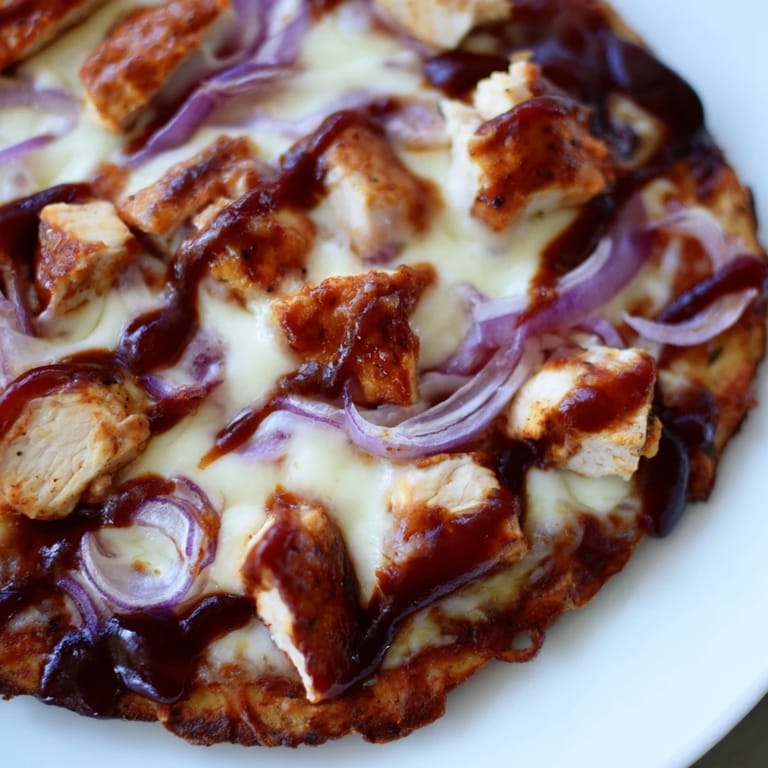A fresh BBQ Chicken Flatbread topped with gooey mozzarella, diced chicken, and sliced onions, garnished with cilantro on a wooden board.  