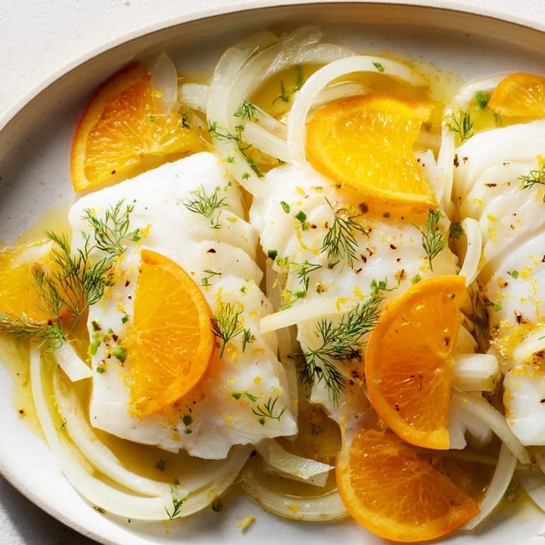 Flaky white cod gently cooked in a savory white wine and vegetable broth, paired with sweet orange and crisp fennel for a light main course.