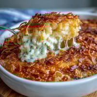 Creamy cheesy hash brown casserole with golden cornflake topping in a baking dish, perfect for Easter dinner.